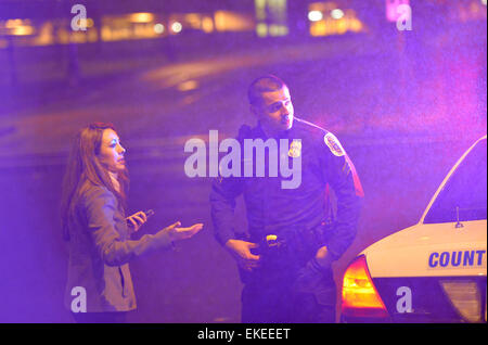 Suitland, USA. 9. April 2015. Ein Journalist spricht mit einem Polizisten auf der Straße neben der U.S. Census Bureau-zentrale nach der Aufnahme passiert beim Büro in Suitland, Maryland, USA, 9. April 2015. Eine Wache in der U.S. Census Bureau-zentrale wurde erschossen und kritisch verwundete Donnerstag, lokale Medien berichteten. Bildnachweis: Yin Bogu/Xinhua/Alamy Live-Nachrichten Stockfoto