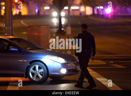 Suitland, USA. 9. April 2015. Ein Polizist einen Fahrer bitten, einen Abstecher auf die Straße neben der U.S. Census Bureau-zentrale nach schießen beim Büro in Suitland, Maryland, USA, 9. April 2015 passiert. Eine Wache in der U.S. Census Bureau-zentrale wurde erschossen und kritisch verwundete Donnerstag, lokale Medien berichteten. Bildnachweis: Yin Bogu/Xinhua/Alamy Live-Nachrichten Stockfoto