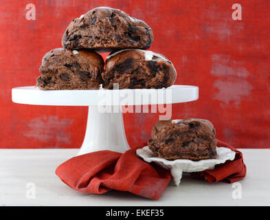 Schokolade Obst Brötchen auf weißen Kuchen stehen auf weißen shabby chic Holztisch mit roten Hintergrund Hintergrund. Stockfoto