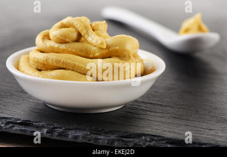 Senfsauce in Schüssel weiß, selektiven Fokus Stockfoto