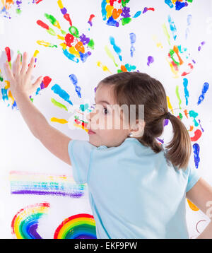 Schöne kleine Mädchen mit den Händen in die Farbe in weiß Stockfoto