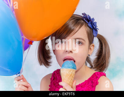 Kleine süße Mädchen mit Eis und Luftballons in weiß Stockfoto