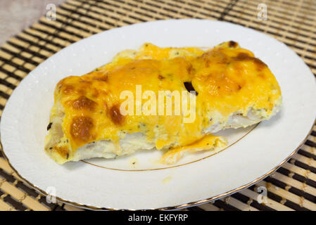 Kabeljau-Filets mit Käse-Sauce auf einem Teller Stockfoto