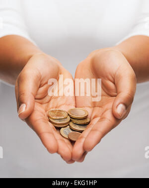 Womans schalenförmige Hände mit Euro-Münzen Stockfoto