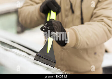 Nahaufnahme des Mannes Eis vom Auto kratzen Stockfoto