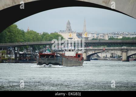 Barge auf der seine unter einer Brücke mit dem Eiffelturm im Hintergrund, Paris, Frankreich. Stockfoto