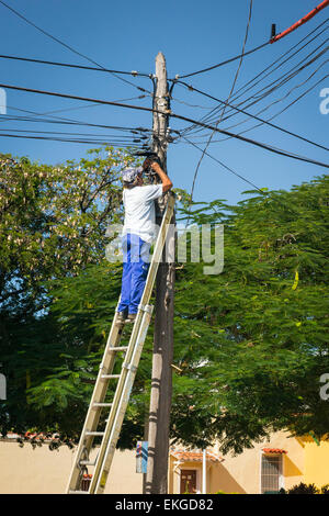 Kuba-Trinidad-Straße Straße Szene Mann auf Leiter arbeiten an Freileitungen elektrischen Strom Kabel Arbeiter Elektriker Stockfoto