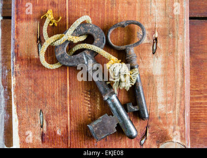 Zwei alte Vintage Keys mit ausgefransten Schnur an Grunge Holz Hintergrund Stockfoto