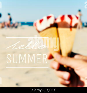 der Text hallo Sommer auf ein unscharfes Bild einige Eis in der Hand eines jungen Mannes am Strand Stockfoto