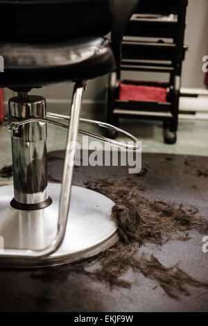 Haar Salon Stuhl Closeup mit Haaren auf den Boden Stockfoto