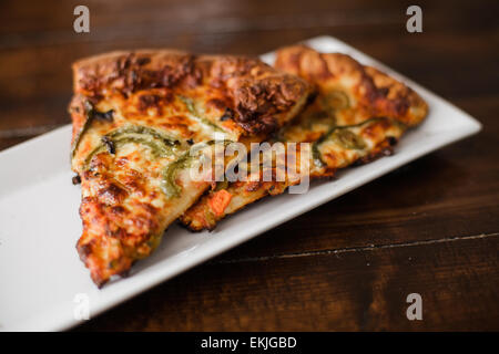 Vegetarische Pizza auf einem weißen Teller Scheiben Stockfoto