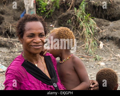 Dschungel, Indonesien - 13. Januar 2015: Eine Frau vom Stamm Korowaya mit Kindern am Ufer des Flusses Stockfoto