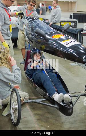 Detroit, Michigan, USA. 9. April 2015. Studenten aus Newburgh (New York) Free Academy, einer öffentlichen High School, passen die Fahrer in einem Auto, das sie entwickelt haben, um in der Shell Eco-Marathon konkurrieren. Der Wettbewerb fordert Schüler, Kraftstoff sparende Fahrzeuge zu bauen. Bildnachweis: Jim West/Alamy Live-Nachrichten Stockfoto