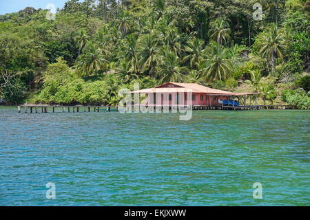 Üppige tropische Küste mit einem Haus und dock über das Wasser auf dem Archipel von Bocas del Toro, Panama Stockfoto