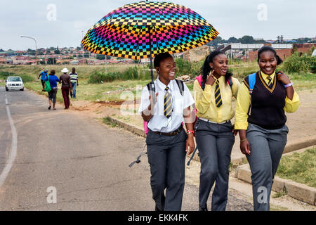 Johannesburg Südafrika, Soweto, Schwarze Teenager Teenager Teenager Mädchen Mädchen, Youngster, weibliche Kinder Kinder Freunde, Studenten Studenten zu Fuß, Umbrel Stockfoto