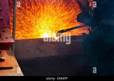 Arbeiter ein Stahlträger von einer alten Brücke mit Funken fliegen herum schneiden. Stockfoto