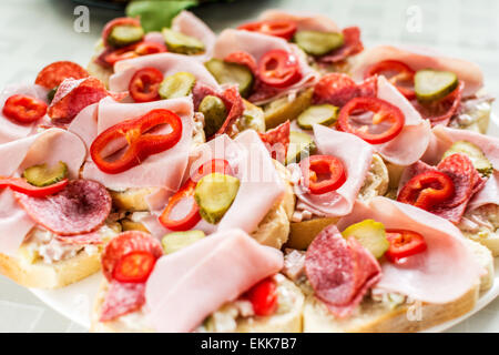 Sandwiches mit Gurke und Wurst und Schinken auf Tisch Stockfoto