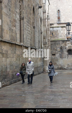 Menschen, die entlang der Straße hinter der Kathedrale an regnerischen Tag in Barcelona Stockfoto