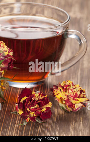 Eine Tasse Tee und trockenen Rosen auf einem Holz-Tisch Stockfoto