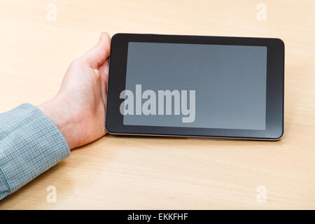 Geschäftsmann Hand mit Tablet-PC mit schwarzen Bildschirm am Bürotisch Stockfoto