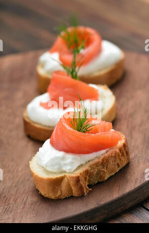 Fischbrötchen mit Lachs und Dill auf Holzbrett Stockfoto