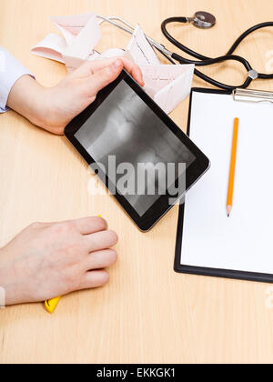 Arzt untersucht Röntgenbild des menschlichen Kniegelenks auf TabletPC Stockfoto