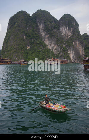 Eine Frau geht es um die Ausflugsboote, Snacks und Getränke zu verkaufen. Ha Long Bay Vietnam. Stockfoto