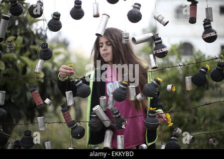 Peking, China. 10. April 2015. Ein palästinensisches Mädchen stellen Blumen in gebrauchten Tränengas abgefeuert durch israelische Truppen während der letzten Auseinandersetzungen Nabi Saleh Village in der Nähe der West Bank Stadt Ramallah 10. April 2015 Kanister. © Fadi Aruri/Xinhua/Alamy Live-Nachrichten Stockfoto