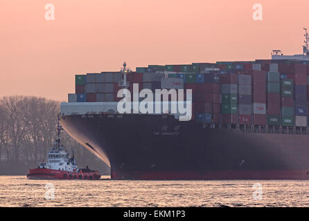 Containerschiff mit Schlepper auf der Elbe, Hamburg Stockfoto