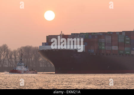 Containerschiff mit Schlepper auf der Elbe, Hamburg Stockfoto