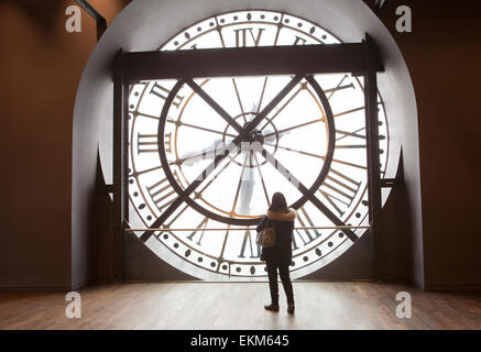 Eine Frau hinter der Stirnfläche eines Orsay Uhren im Pariser Musée d'Orsay Stockfoto