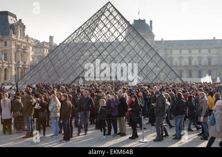 Die Schlange der Besucher an der Louvre-Pyramide und der Palast in Paris Stockfoto