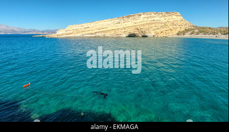 Taucher Schnorcheln in Türkis farbigen Bucht von Messara, Matala, berühmt für seinen Strand, Felsen und Höhlen, Kreta, Griechenland. Stockfoto