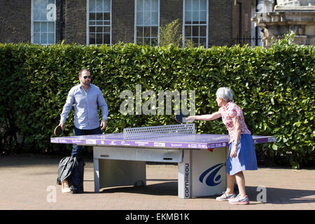Spielen Sie Tischtennis im Park zur Mittagszeit in London Stockfoto