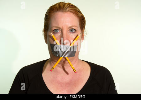 Zensur von Freedom of Speech oder Freiheit der Presse ausgedrückt von einer Frau mit Klebeband und Stifte in den Mund Stockfoto
