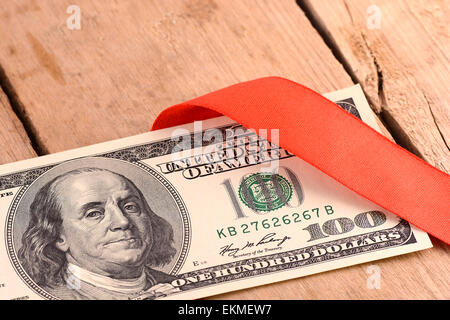 Hundert Dollar Bills Wrapper in Red Ribbon Stockfoto