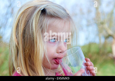 Nahaufnahme eines Kindes blonde Mädchen trinken Limonade außerhalb der Sommerzeit Stockfoto