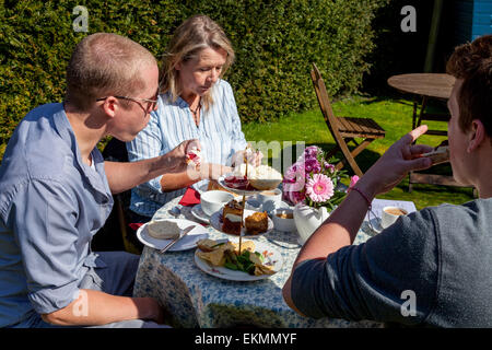 Eine Familie genießen Sie eine traditionellen englischen Nachmittag Tee, Glynde, Sussex, UK Stockfoto