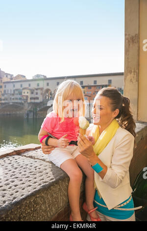 Glückliche Mutter und Babymädchen Essen ein Eis in der Nähe von Ponte Vecchio in Florenz, Italien Stockfoto