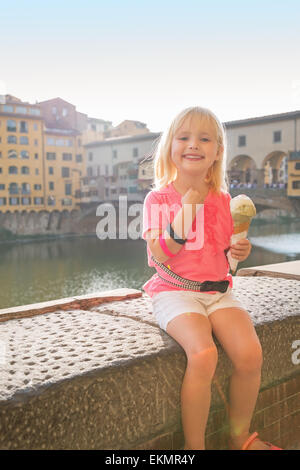 Porträt von glückliches Babymädchen Essen ein Eis in der Nähe von Ponte Vecchio in Florenz, Italien Stockfoto