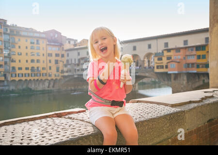 Glückliches Babymädchen Essen ein Eis in der Nähe von Ponte Vecchio in Florenz, Italien Stockfoto