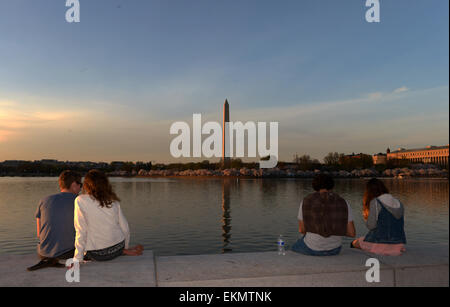 Washington, DC, USA. 12. April 2015. Menschen sitzen um die Tidal Basin in Washington, D.C., Hauptstadt der USA, 12. April 2015. Die Kirschblüten in der amerikanischen Hauptstadt stehen in voller Blüte an diesem Wochenende. Bildnachweis: Yin Bogu/Xinhua/Alamy Live-Nachrichten Stockfoto