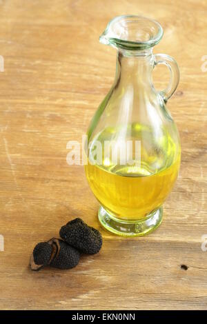 Olivenöl, gewürzt mit schwarzem Trüffel auf einem Holztisch Stockfoto