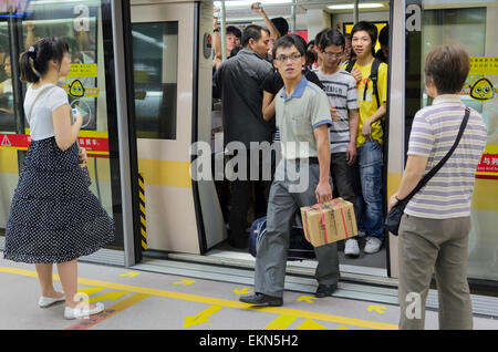 Passagiere steigen Sie eine u-Bahn in Guangzhou, China. Bahnsteigtüren ist zwischen der Plattform Zugtüren klar ersichtlich. Öffentliche Verkehrsmittel; u-Bahn Stockfoto