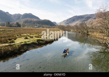 Mensch und Hund angesehen von der Chinesisch-Brücke paddeln Kanu am Fluss Derwent in Borrowdale, Lake District, England, UK Stockfoto