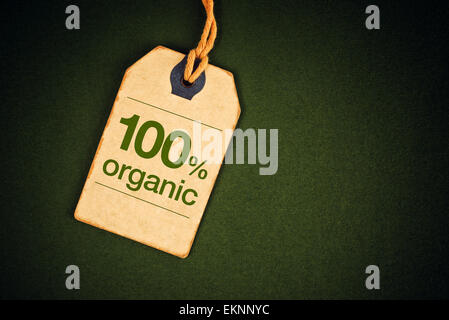 100 Prozent Bio-Lebensmittel auf Vintage Label Tag Preisschild auf grüne Grunge strukturierten Hintergrund, Ansicht von oben. Stockfoto