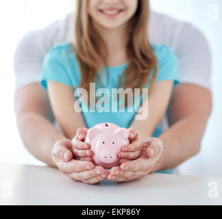 Nahaufnahme von Familienhand mit Sparschwein Stockfoto