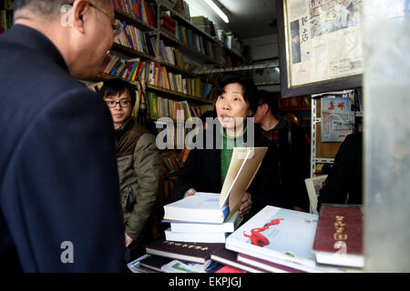 (150413)--HEFEI, 13. April 2015 (Xinhua)--Chen Guixia (R vorne), Besitzer der Zengzhi Antiquariat, spricht mit den Lesern in der Buchhandlung in Hefei, Hauptstadt der ostchinesischen Provinz Anhui, 13. April 2015. Zhu Chuanguo begann 52 und seine Frau Chen Guixia Zengzhi Antiquariat in Hefei vor 15 Jahren. Aufgrund Zhus Verschlechterung Rektumkarzinom, das Paar verbrachte fast ihre gesamten Ersparnisse und die Buchhandlung war das Risiko wird heruntergefahren. Vor kurzem einen alten Kunden gebucht über das Paar und ihre Geschichte online, der viele Anwohner um Bücher zu kaufen, als ein Weg, um das Paar angezogen. Stockfoto