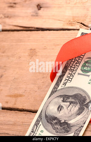 Hundert Dollar Bills Wrapper in Red Ribbon Stockfoto