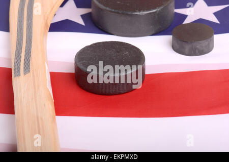 Hockey-Ausrüstung, einschließlich einen Stock und Puck auf eine amerikanische Flagge, eine patriotische amerikanische Sportart abzuleiten. Stockfoto